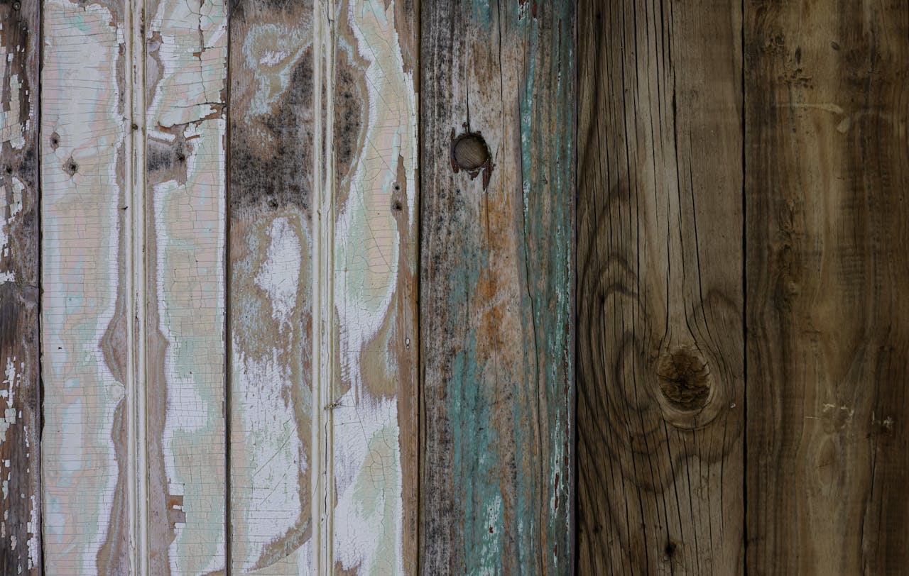 A close-up of an aged, weathered wooden surface with peeling paint and unique textures.